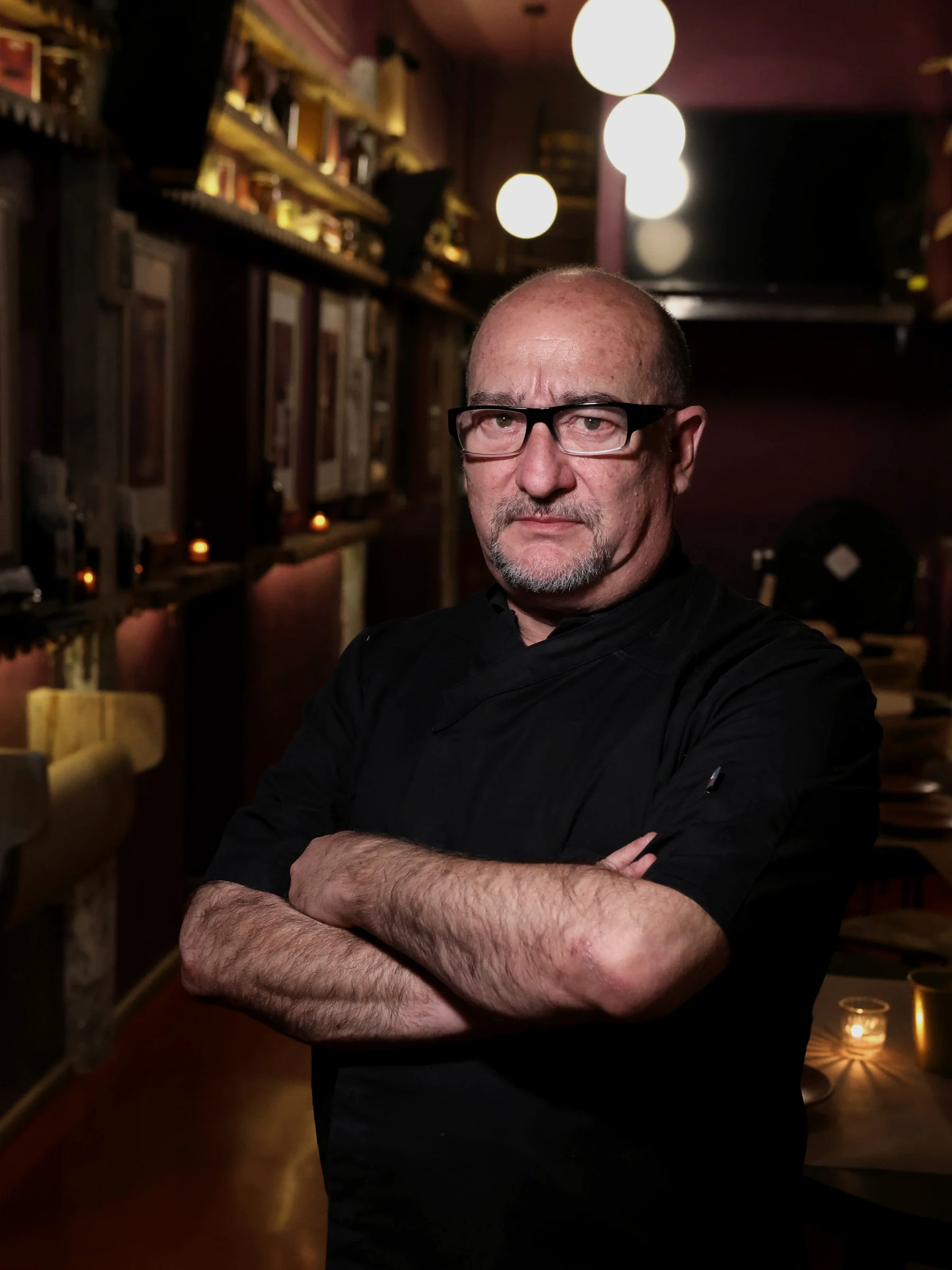 Chef de HEIMAT en la cocina, ambiente cálido y oscuro